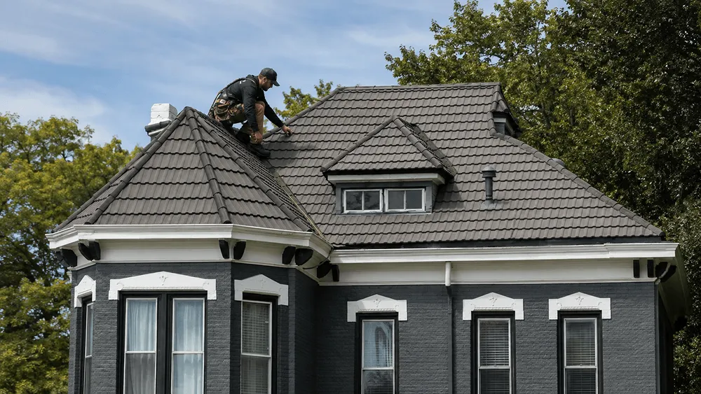 Roofer doing a roof inspection in Independence looking at flashing, pipe boots, and shingles on an older home in Missouri